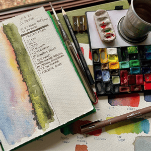 Paint palette with canvas book and brushes