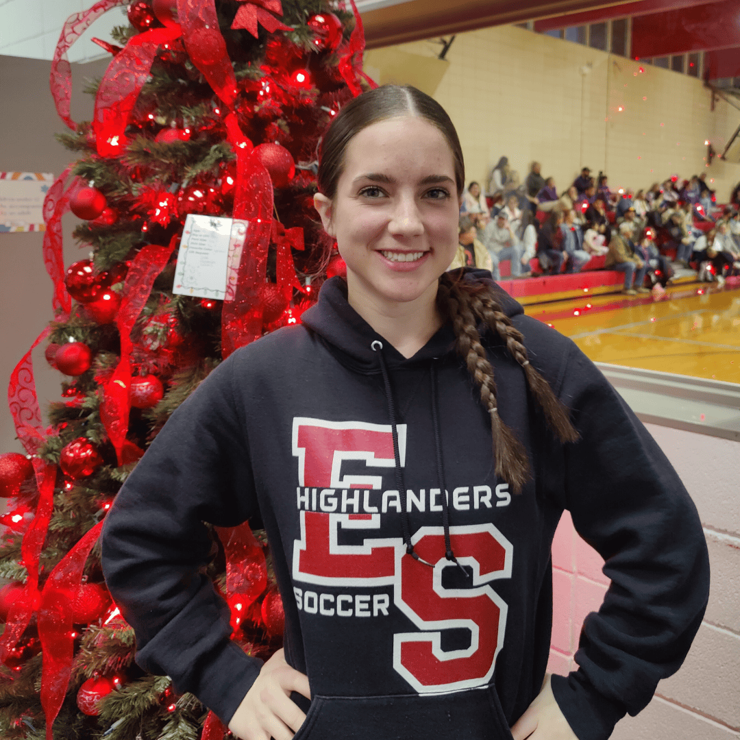 Dark Haired girl with braids and tree with red decoration