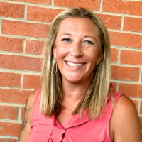 Woman with blonde hair and brick wall